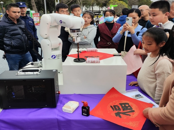 喜乐注册机器人“新一代书法大师”助力 2025年龙岗区迎春花市，挥墨迎春送福字